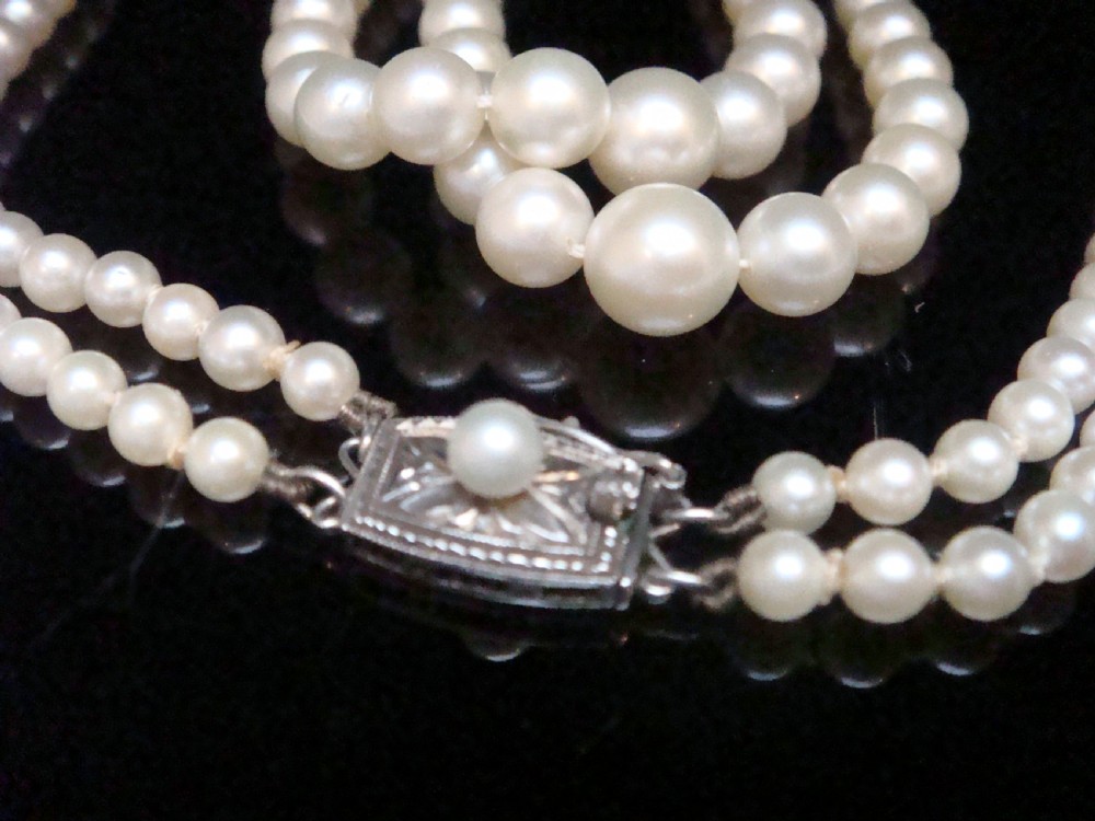 A double strand graduated white cultured pearl necklace featuring an ornate silver box clasp set with a single pearl. View VII