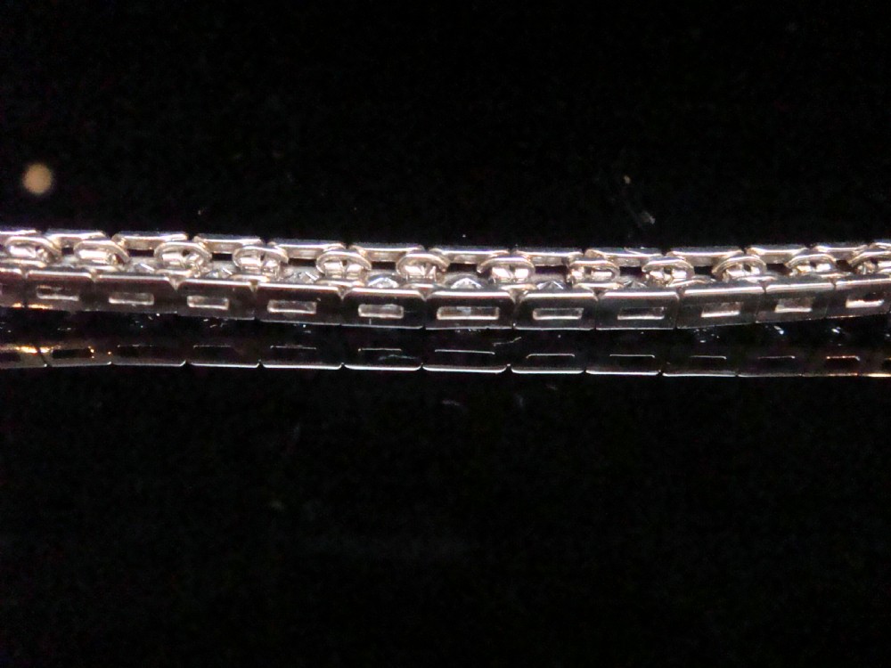 An Edwardian 18ct white gold line bracelet featuring a continuous row of round brilliant cut diamonds set in square box links. View II
