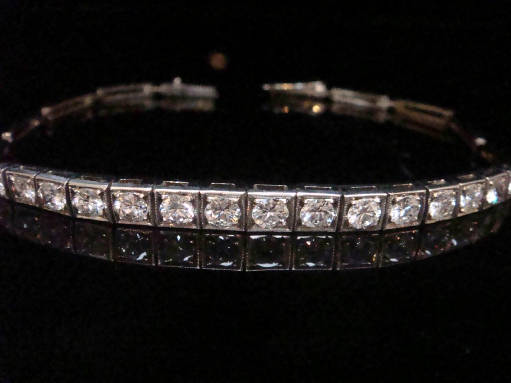 An Edwardian 18ct white gold line bracelet featuring a continuous row of round brilliant cut diamonds set in square box links. View III