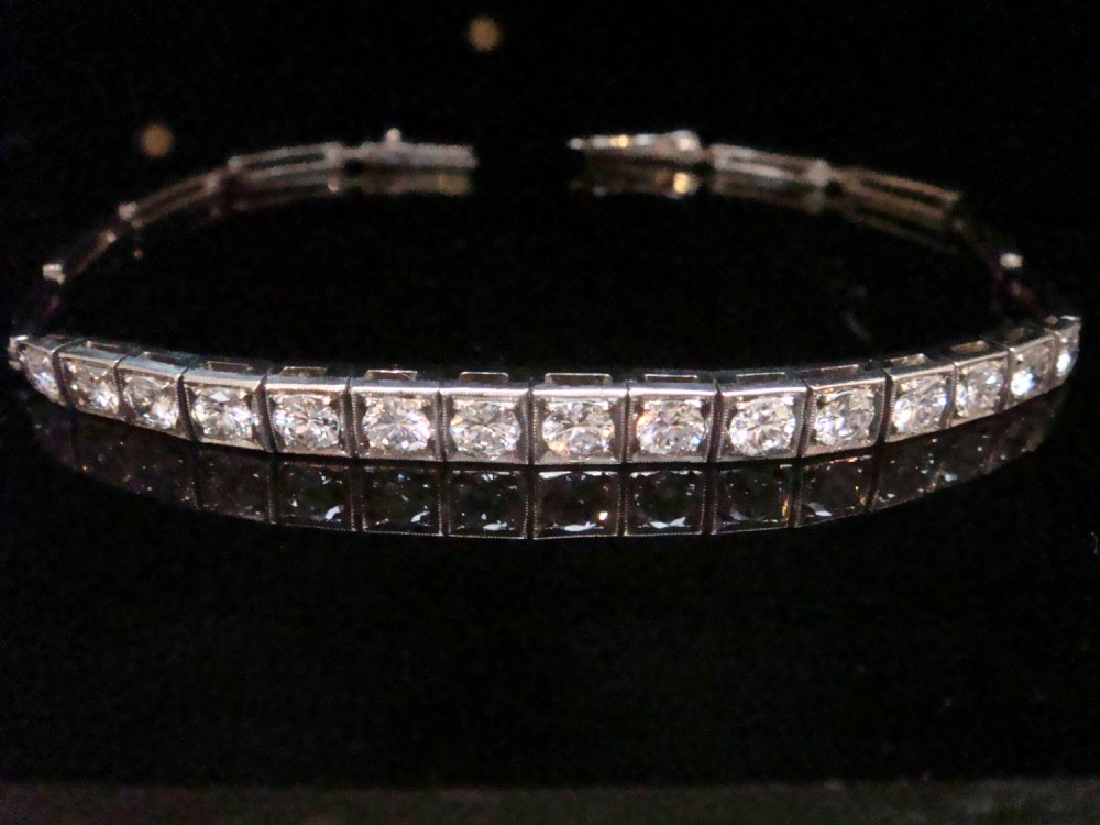 An Edwardian 18ct white gold line bracelet featuring a continuous row of round brilliant cut diamonds set in square box links. View IV