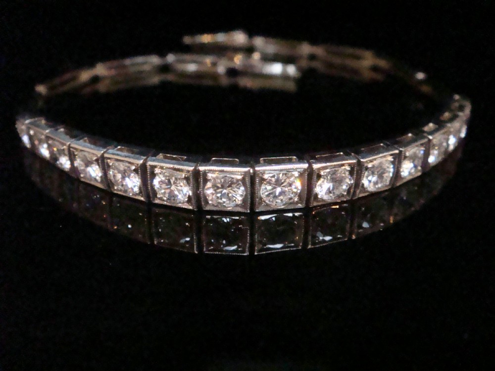 An Edwardian 18ct white gold line bracelet featuring a continuous row of round brilliant cut diamonds set in square box links. View VII