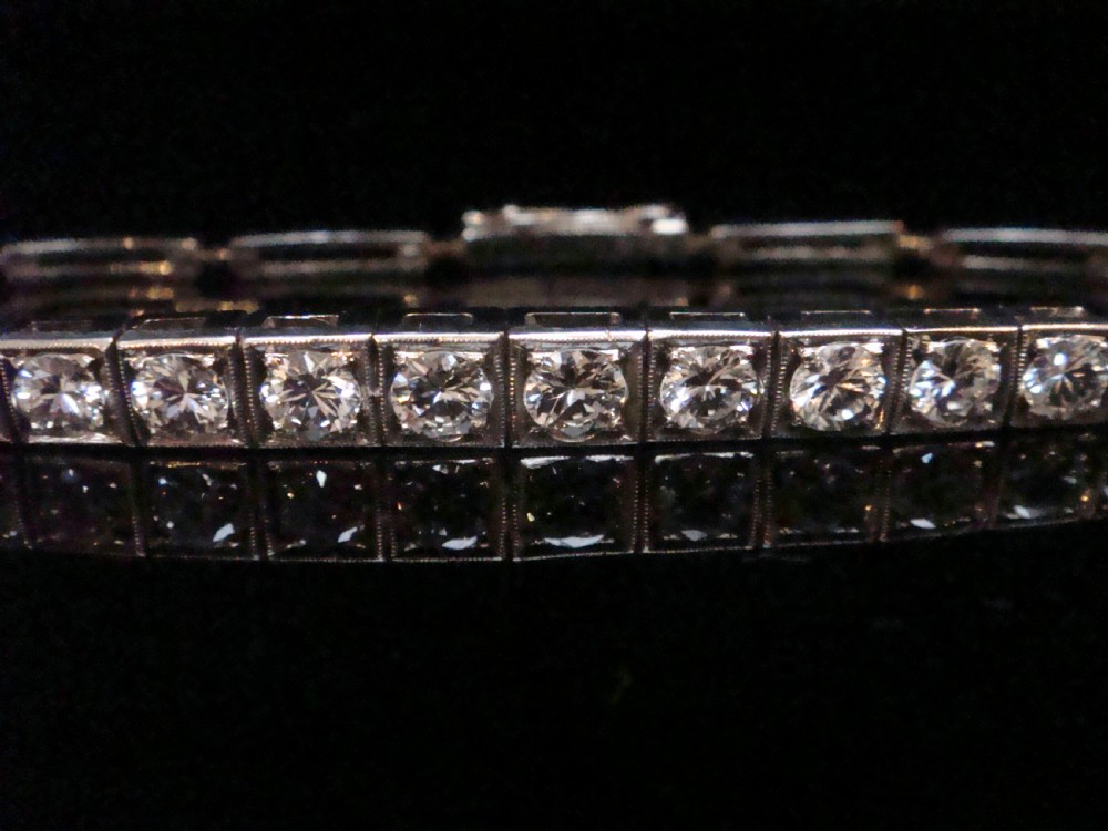 An Edwardian 18ct white gold line bracelet featuring a continuous row of round brilliant cut diamonds set in square box links. View VIII