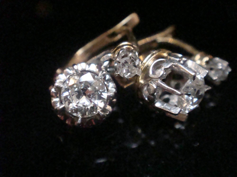 A pair of Edwardian 18ct yellow gold drop earrings featuring old cut diamonds set in coronet claw mountings.