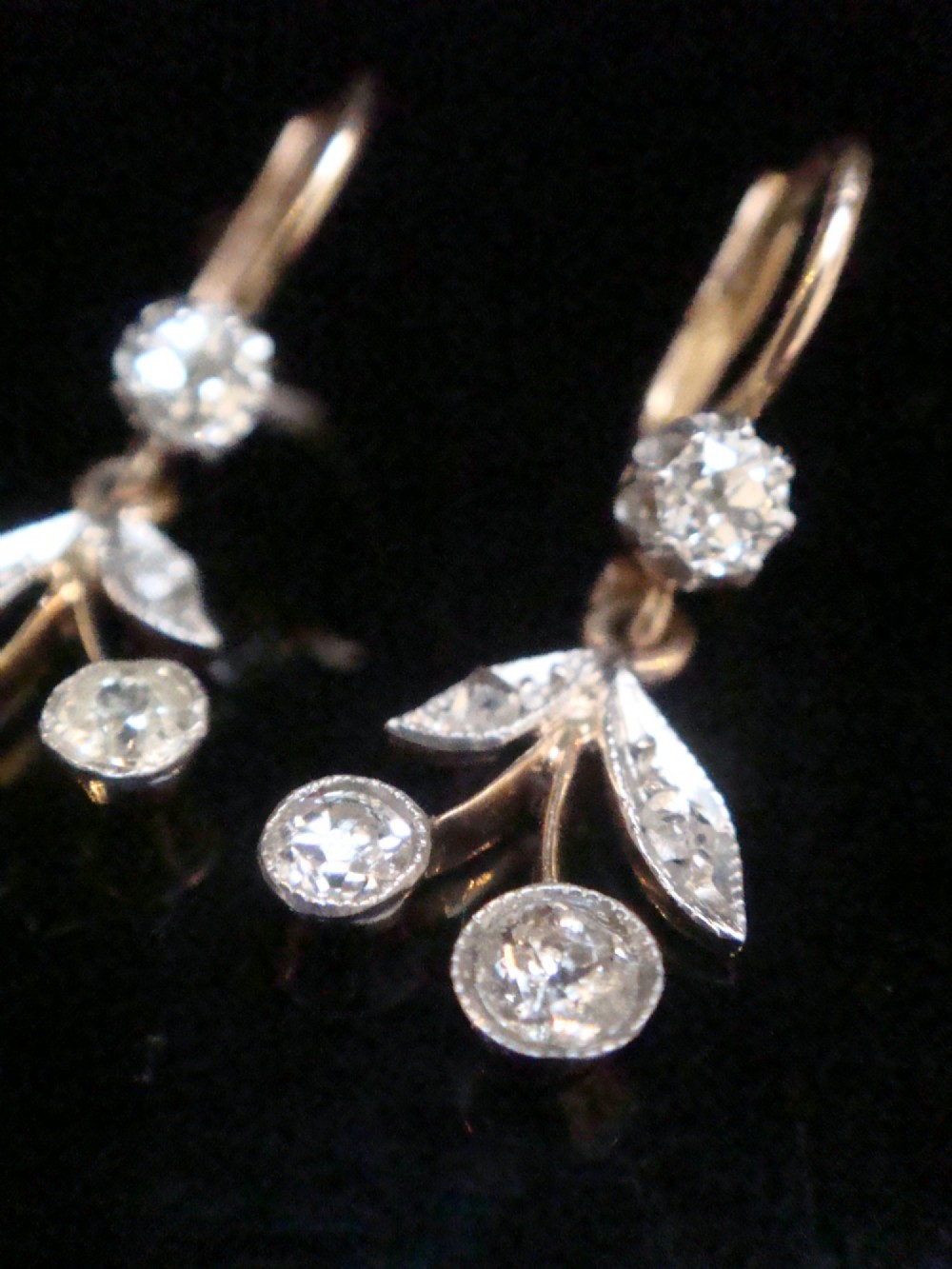 A pair of French Edwardian 18ct yellow gold drop earrings featuring a botanical leaf design set with old cut diamonds.