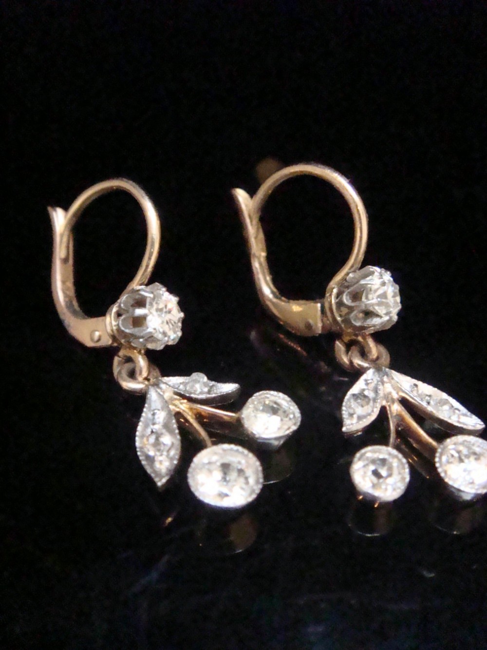 A pair of French Edwardian 18ct yellow gold drop earrings featuring a botanical leaf design set with old cut diamonds. View IV