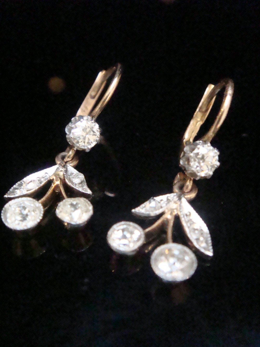 A pair of French Edwardian 18ct yellow gold drop earrings featuring a botanical leaf design set with old cut diamonds. View V