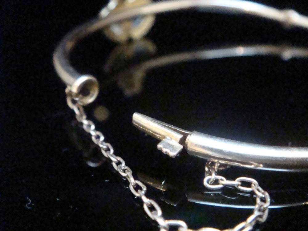An antique 15ct gold hinged bangle featuring two heart-shaped cabochon moonstones framed by small seed pearls. View II