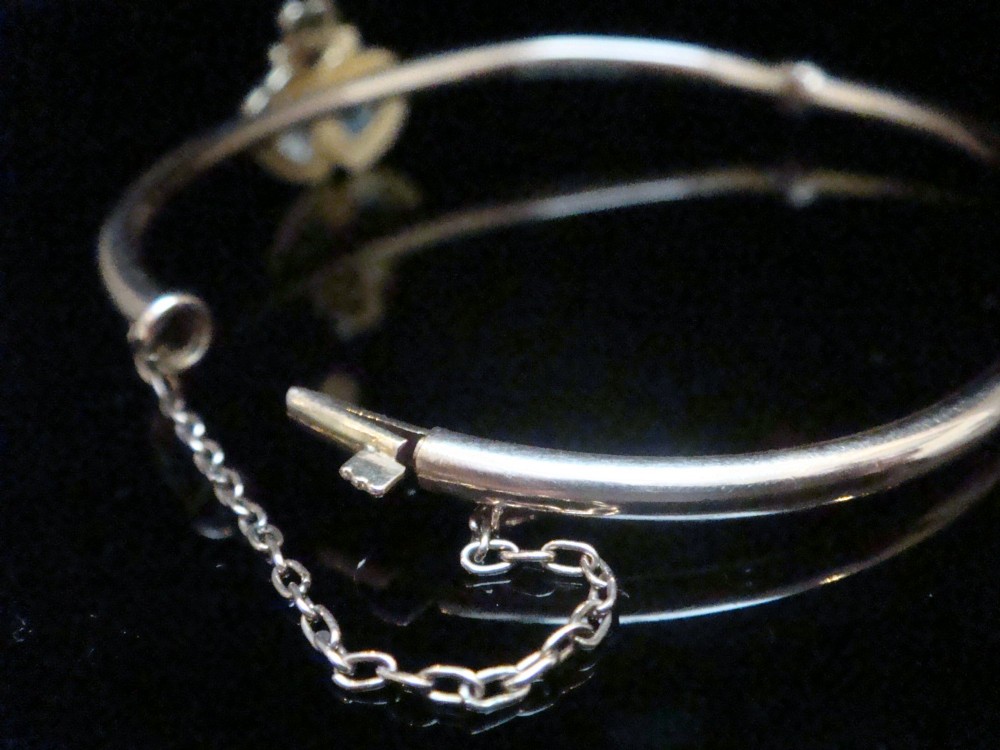 An antique 15ct gold hinged bangle featuring two heart-shaped cabochon moonstones framed by small seed pearls. View III