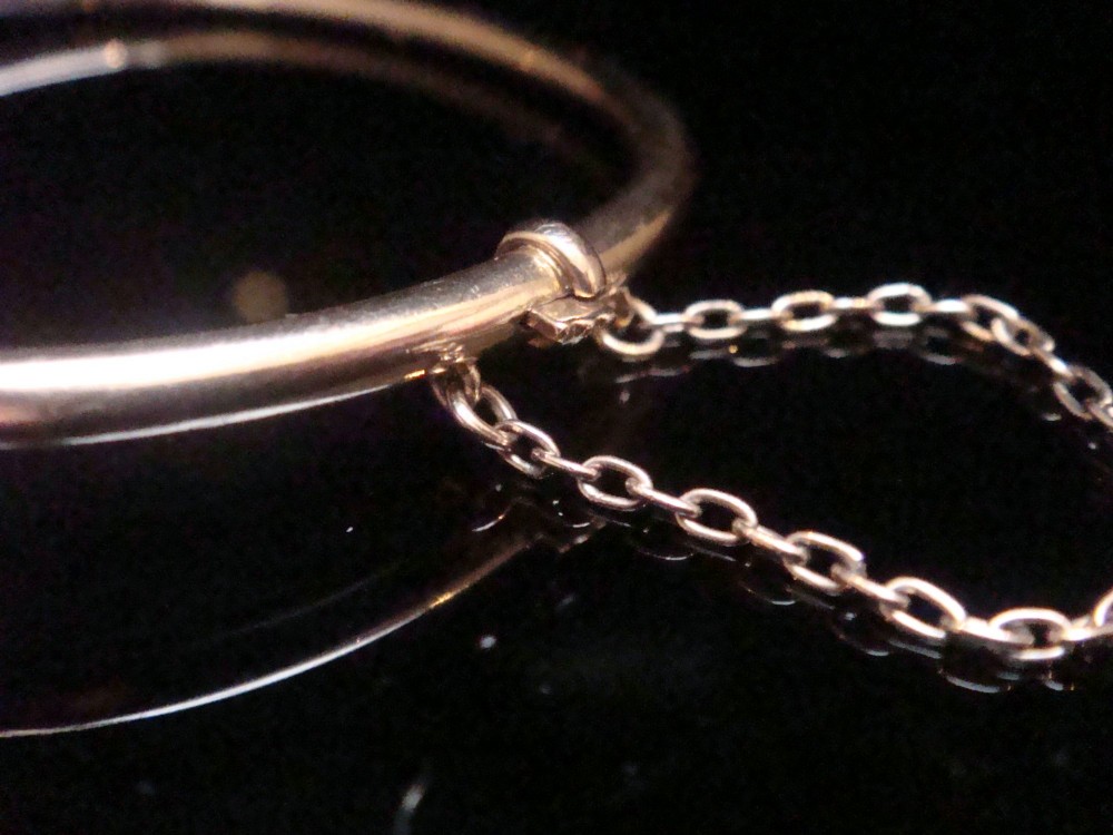 An antique 15ct gold hinged bangle featuring two heart-shaped cabochon moonstones framed by small seed pearls. View IV