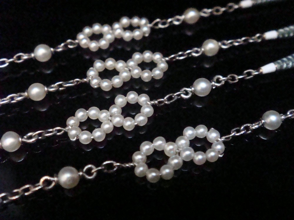 An Edwardian platinum chain detailed with small pearl clusters, single saltwater pearls, and delicate turquoise guilloche enamel links. View II