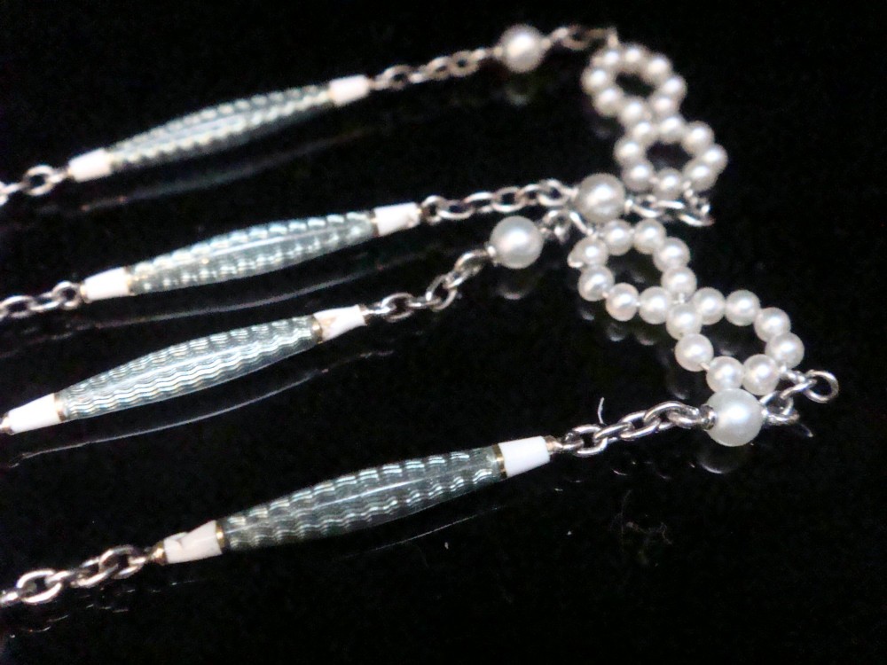 An Edwardian platinum chain detailed with small pearl clusters, single saltwater pearls, and delicate turquoise guilloche enamel links. View III