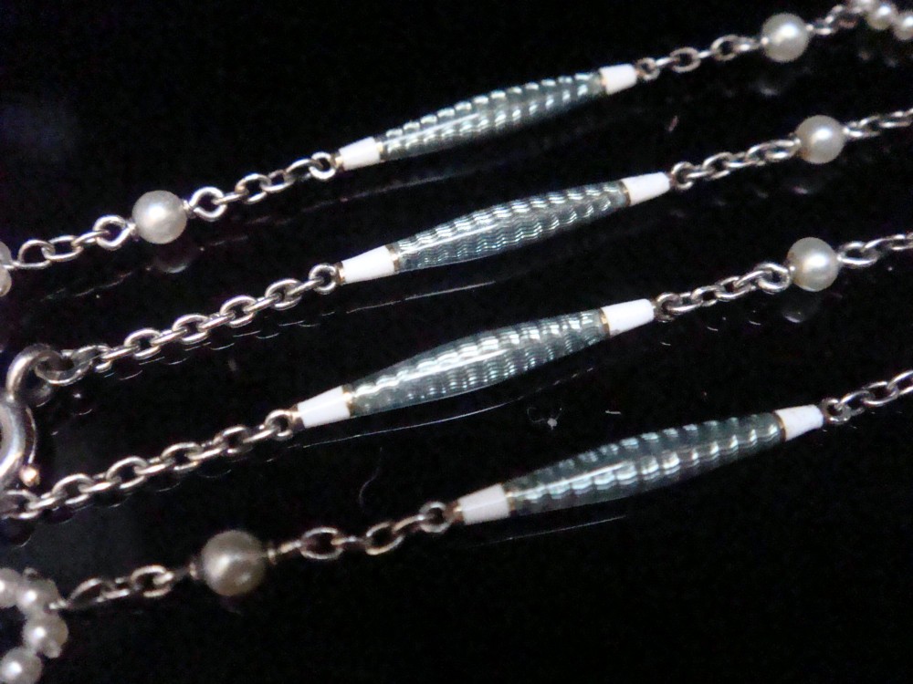 An Edwardian platinum chain detailed with small pearl clusters, single saltwater pearls, and delicate turquoise guilloche enamel links. View V