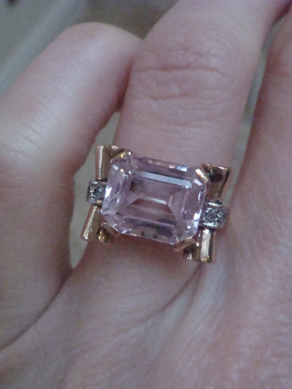 A Retro 18ct gold tank cocktail ring featuring an emerald cut pink kunzite central gemstone flanked by diamond accent bands. View II