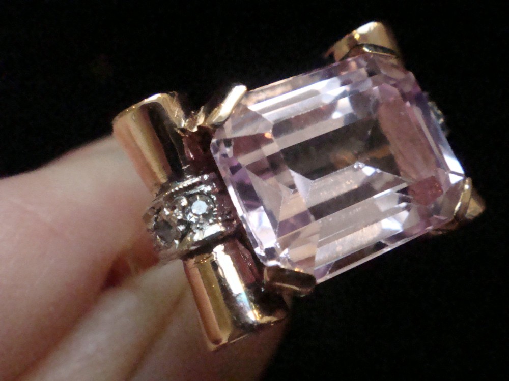 A Retro 18ct gold tank cocktail ring featuring an emerald cut pink kunzite central gemstone flanked by diamond accent bands. View V