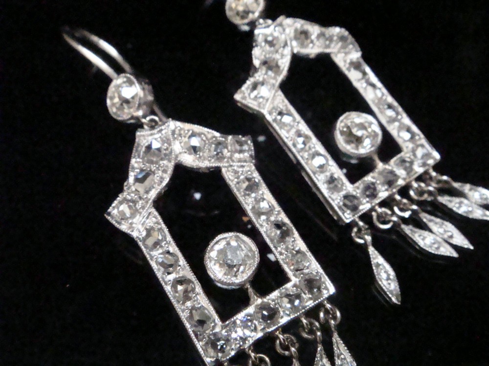 A pair of platinum Art Deco drop earrings featuring openwork geometric frames set with old-cut diamonds and dangling diamond leaf fringes. View III