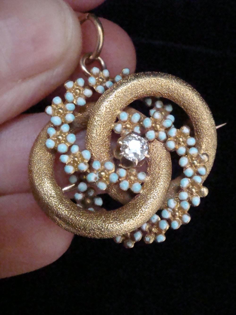 Victorian 18ct textured gold lovers knot brooch and pendant featuring light blue enamelled forget-me-not flowers and a central solitaire diamond. View VI
