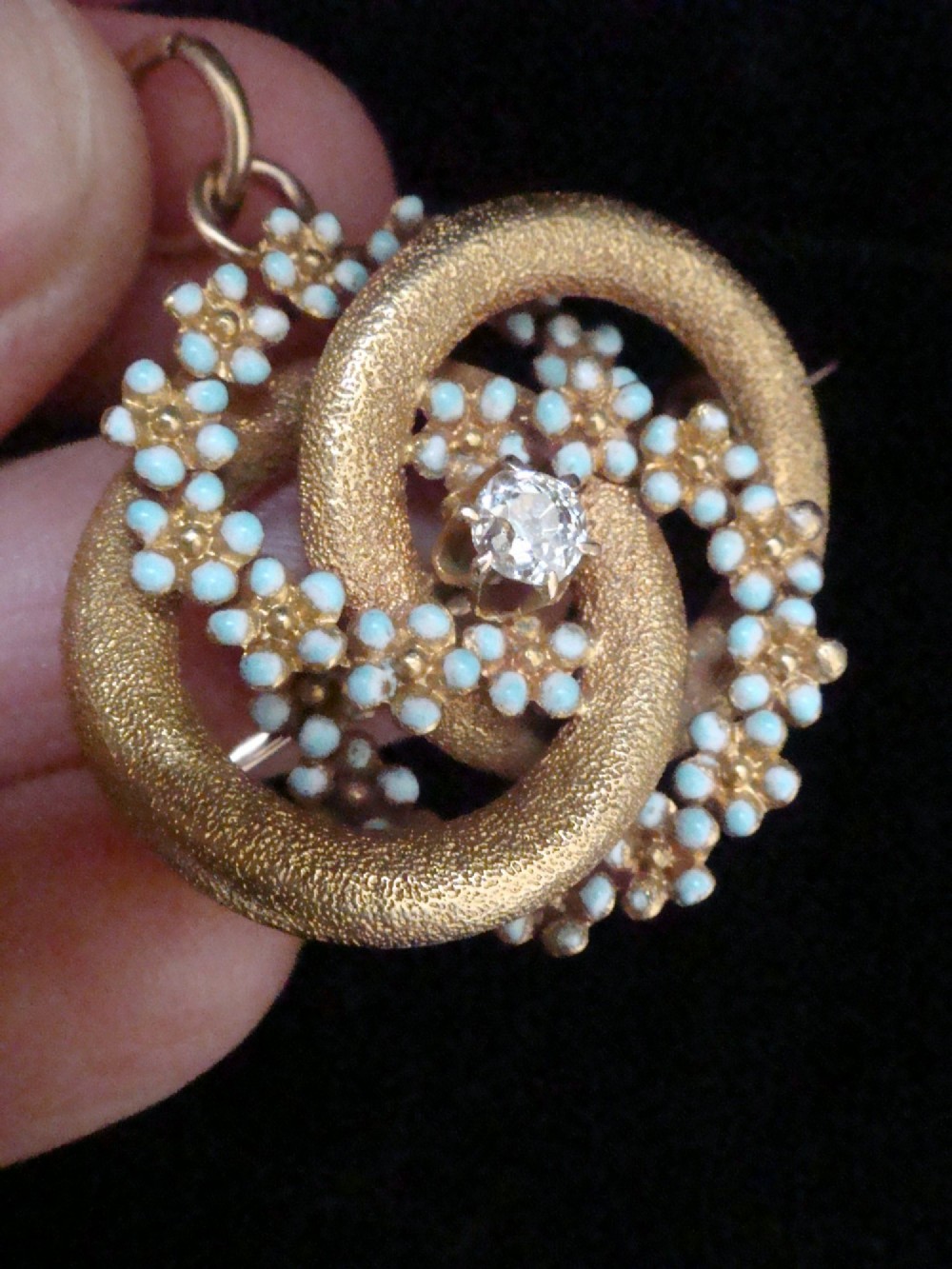 Victorian 18ct textured gold lovers knot brooch and pendant featuring light blue enamelled forget-me-not flowers and a central solitaire diamond. View V