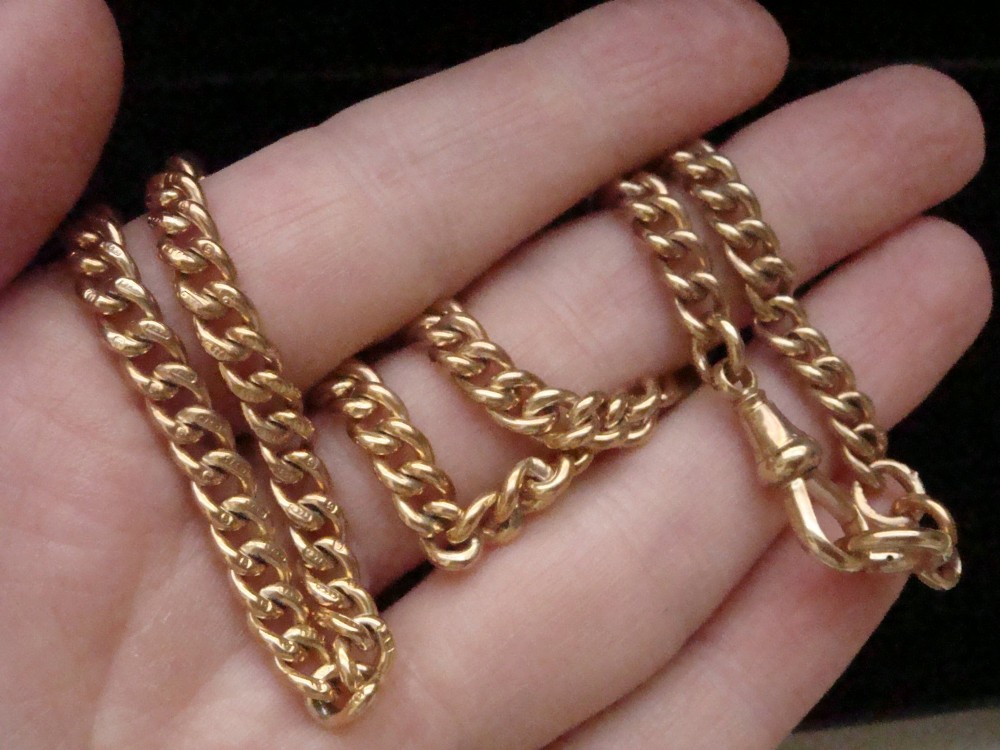 An Edwardian 9ct yellow gold curb link chain featuring a swivel clip clasp and individual hallmark stamps on each link. View IV