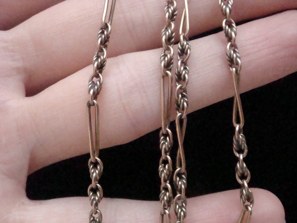 An Edwardian 9ct yellow gold chain featuring alternating twisted rope links, elongated wire links, and a swivel clasp. View IV