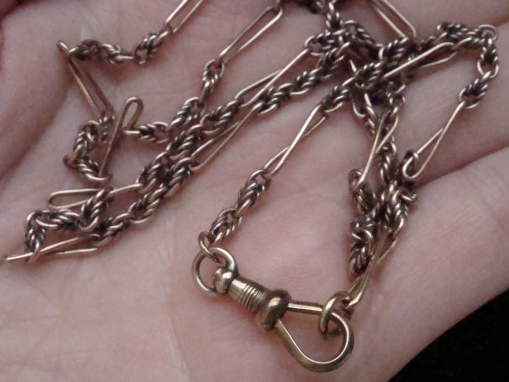 An Edwardian 9ct yellow gold chain featuring alternating twisted rope links, elongated wire links, and a swivel clasp. View V
