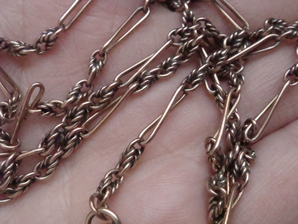 An Edwardian 9ct yellow gold chain featuring alternating twisted rope links, elongated wire links, and a swivel clasp. View VI
