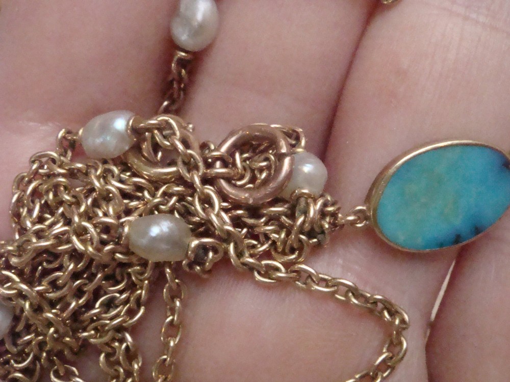 An Edwardian 15ct yellow gold longuard chain featuring oval turquoise cabochons set in collet mounts interspersed with natural pearls. View V