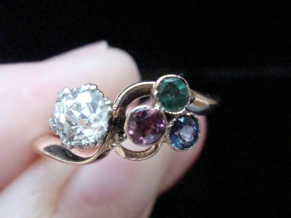 An Edwardian 18ct gold swirl ring featuring a brilliant diamond set alongside a cluster of sapphire, emerald, and pink tourmaline gemstones. View III