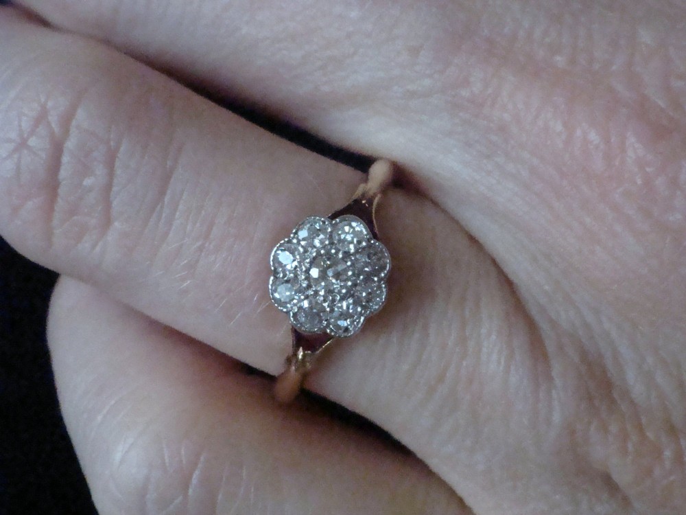 An Edwardian diamond cluster ring featuring a flower-shaped platinum head set on a yellow gold band. View III