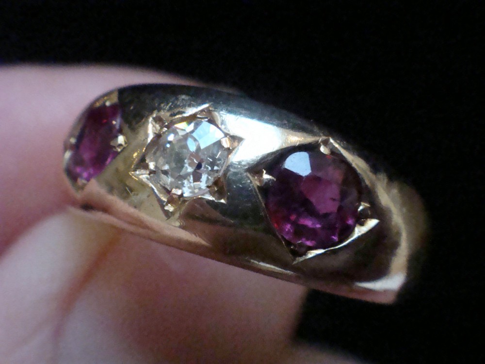 An Edwardian 18ct yellow gold gypsy band ring set with a central old cut diamond flanked by two rubies in star-shaped recessed mountings. View III
