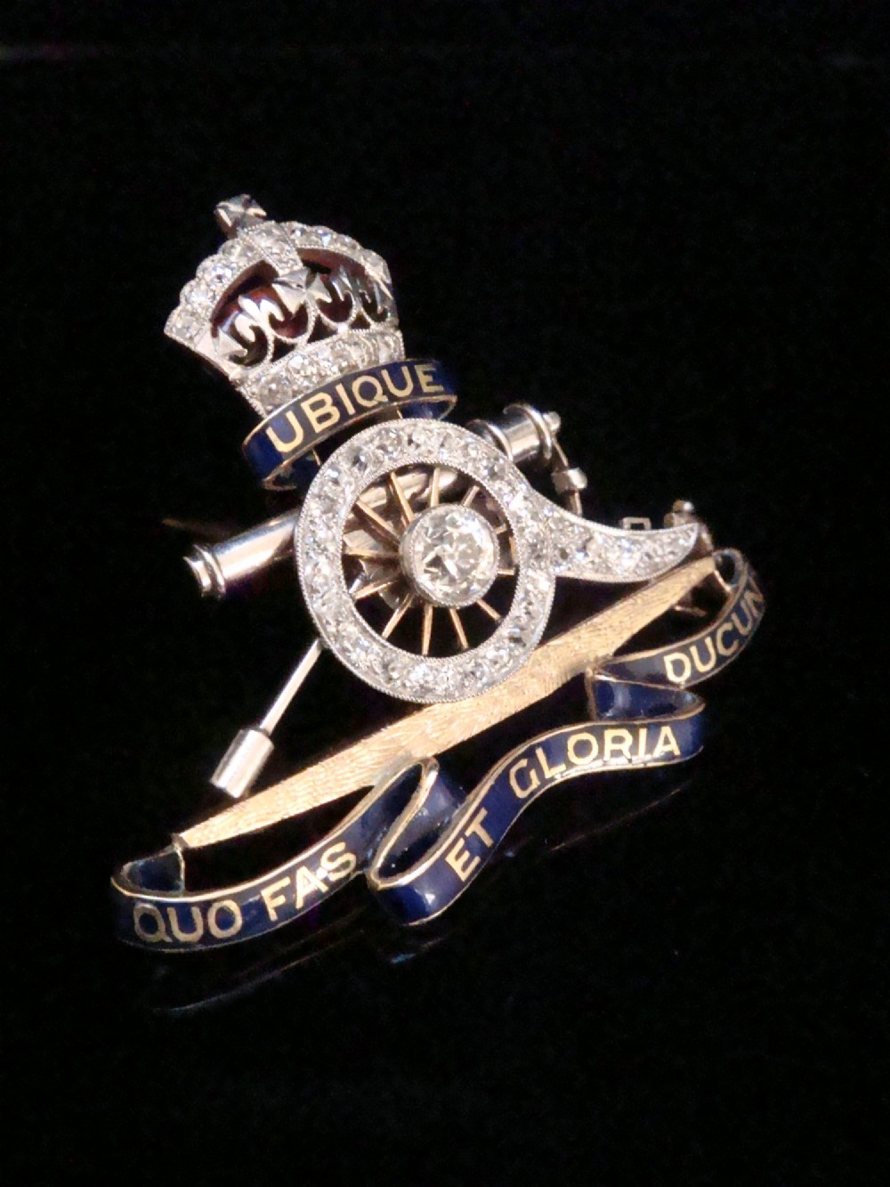 An Edwardian platinum and gold Royal Artillery badge brooch featuring blue guilloche enamel mottos and diamond settings. View IV