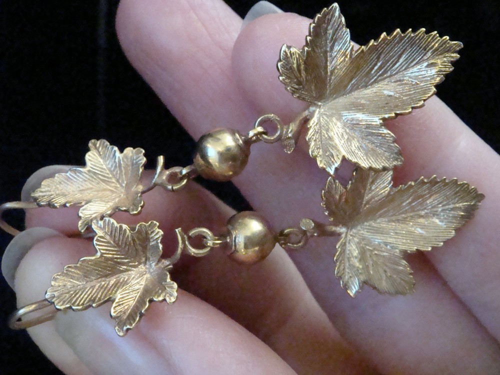 A pair of Edwardian 9ct yellow gold drop earrings featuring detailed leaf motifs suspended from small gold beads and shepherd hooks. View III