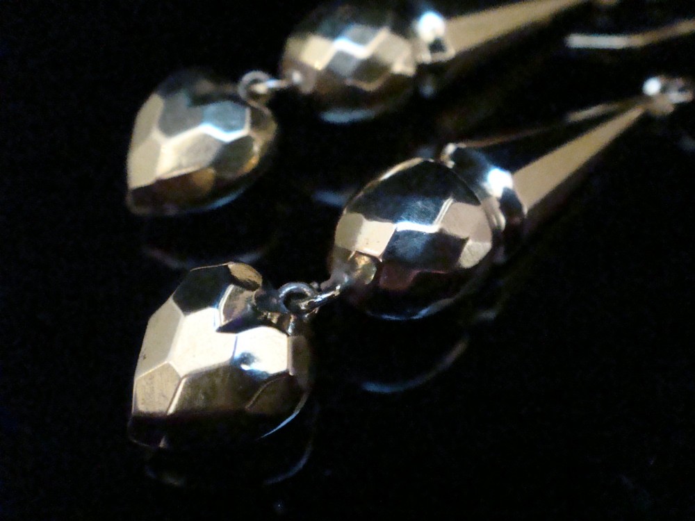 A pair of Edwardian 9ct yellow gold drop earrings featuring geometric faceted tapered bars and faceted heart pendants hanging from hook wires. View II