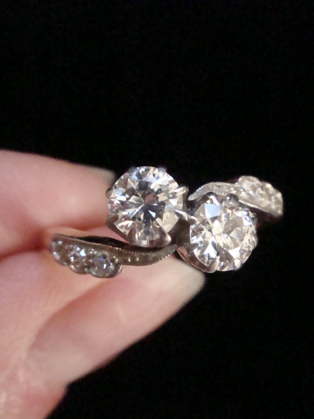 An Edwardian two-stone diamond crossover ring set in platinum and yellow gold with accent diamonds along the curved shoulders. View II