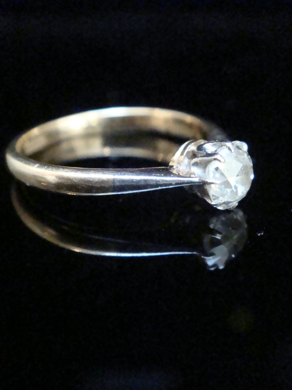 An Edwardian single stone diamond ring featuring a single central diamond set in a platinum claw setting on an eighteen carat gold band. View II