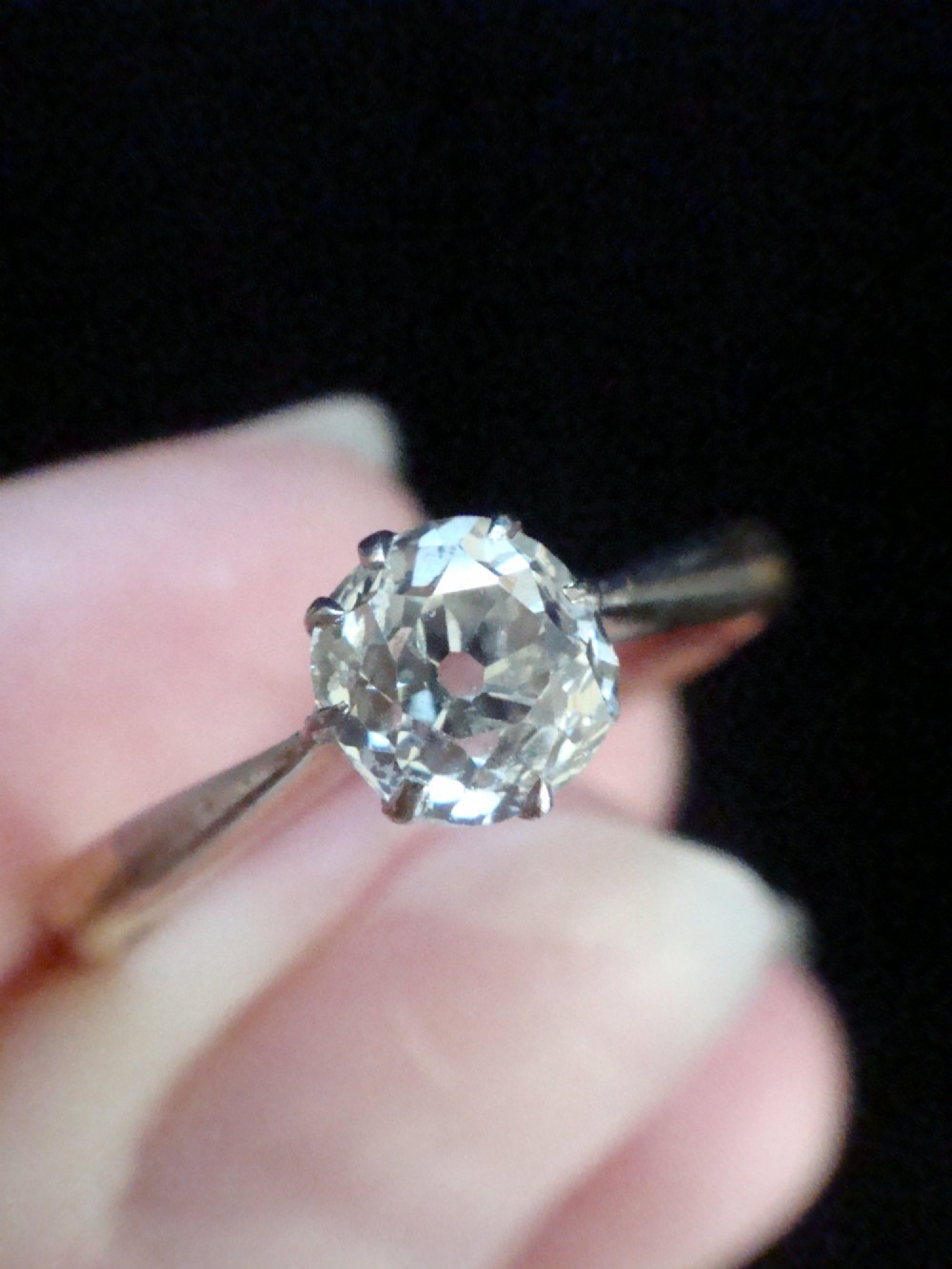 An Edwardian single stone diamond ring featuring a single central diamond set in a platinum claw setting on an eighteen carat gold band. View III