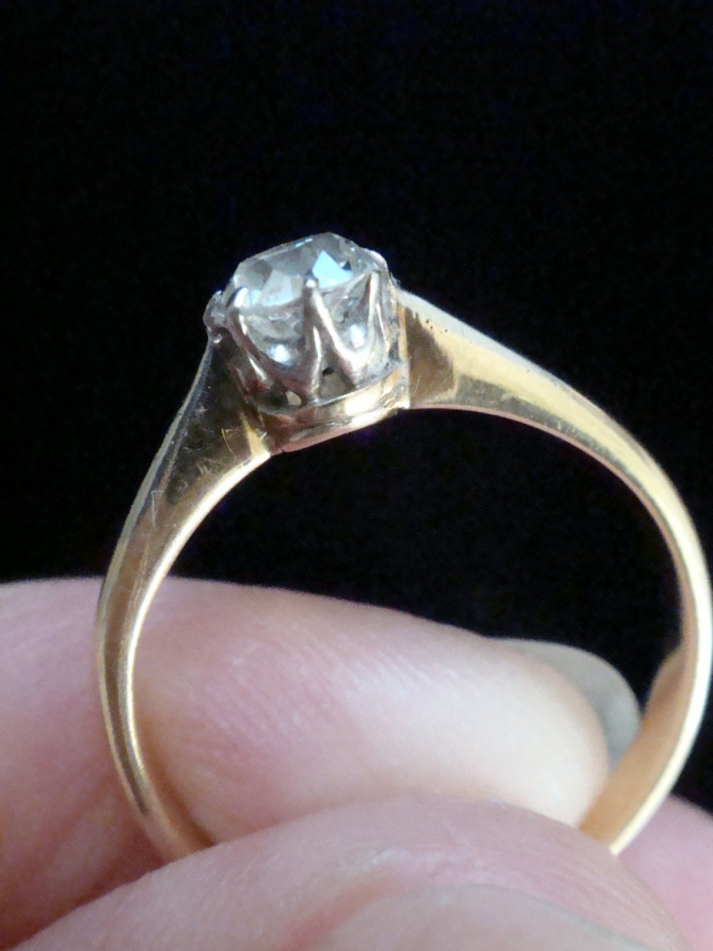 An Edwardian single stone diamond ring featuring a single central diamond set in a platinum claw setting on an eighteen carat gold band. View IV