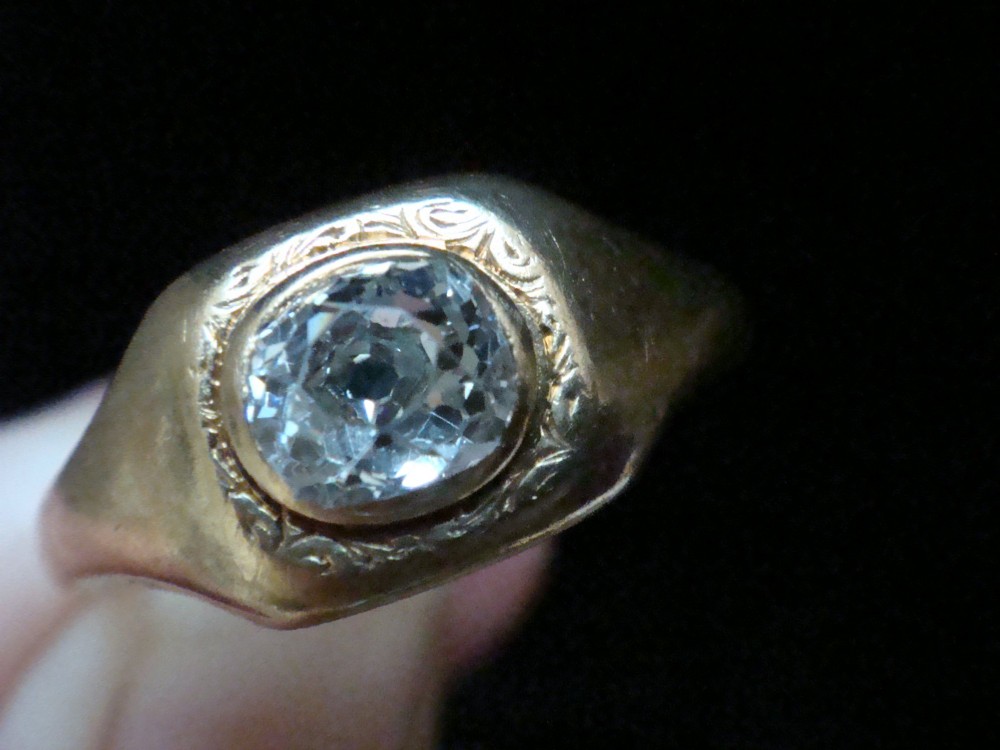 A Victorian 18ct yellow gold gypsy ring set with a single old cut diamond in a flush rubover bezel with hand engraving. View V