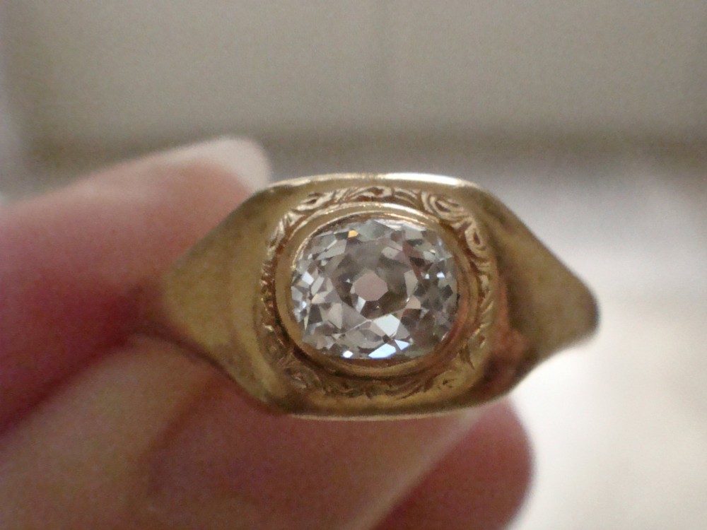 A Victorian 18ct yellow gold gypsy ring set with a single old cut diamond in a flush rubover bezel with hand engraving. View IX