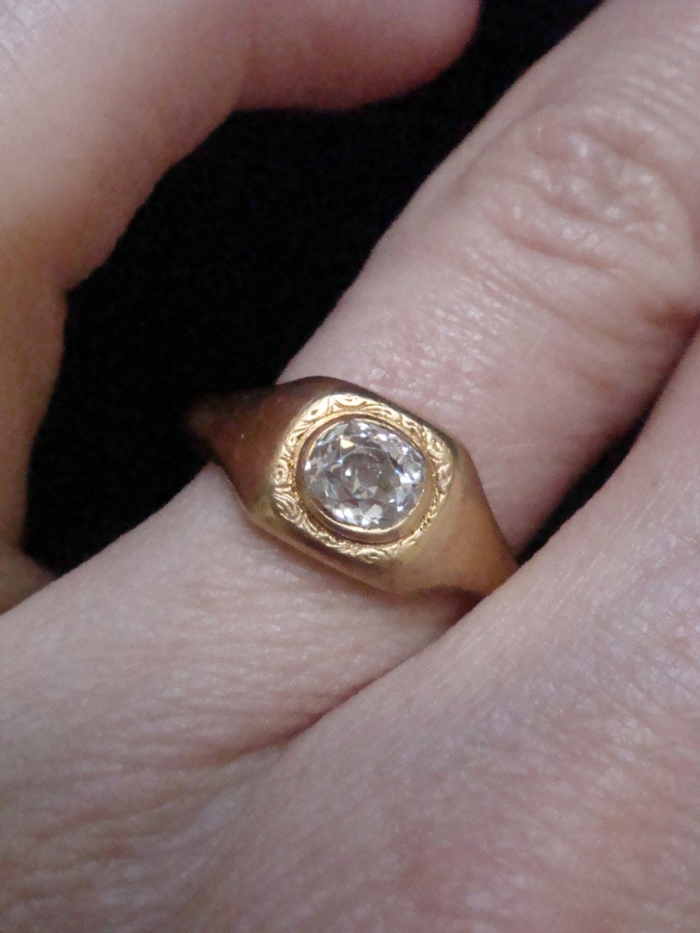 A Victorian 18ct yellow gold gypsy ring set with a single old cut diamond in a flush rubover bezel with hand engraving. View VI