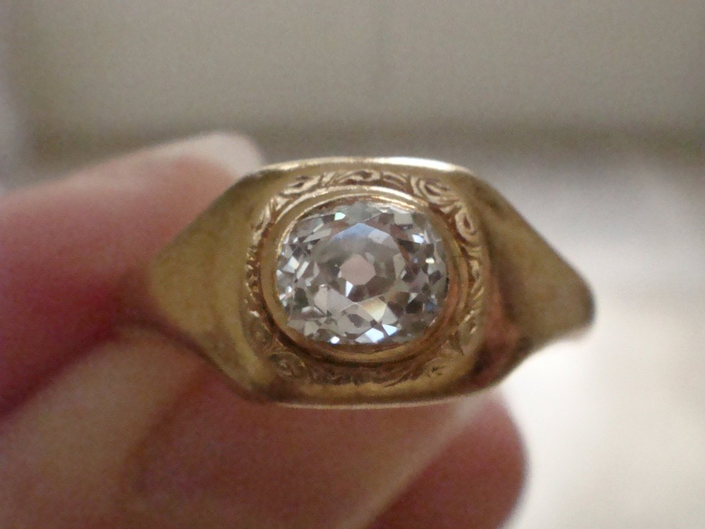 A Victorian 18ct yellow gold gypsy ring set with a single old cut diamond in a flush rubover bezel with hand engraving. View X