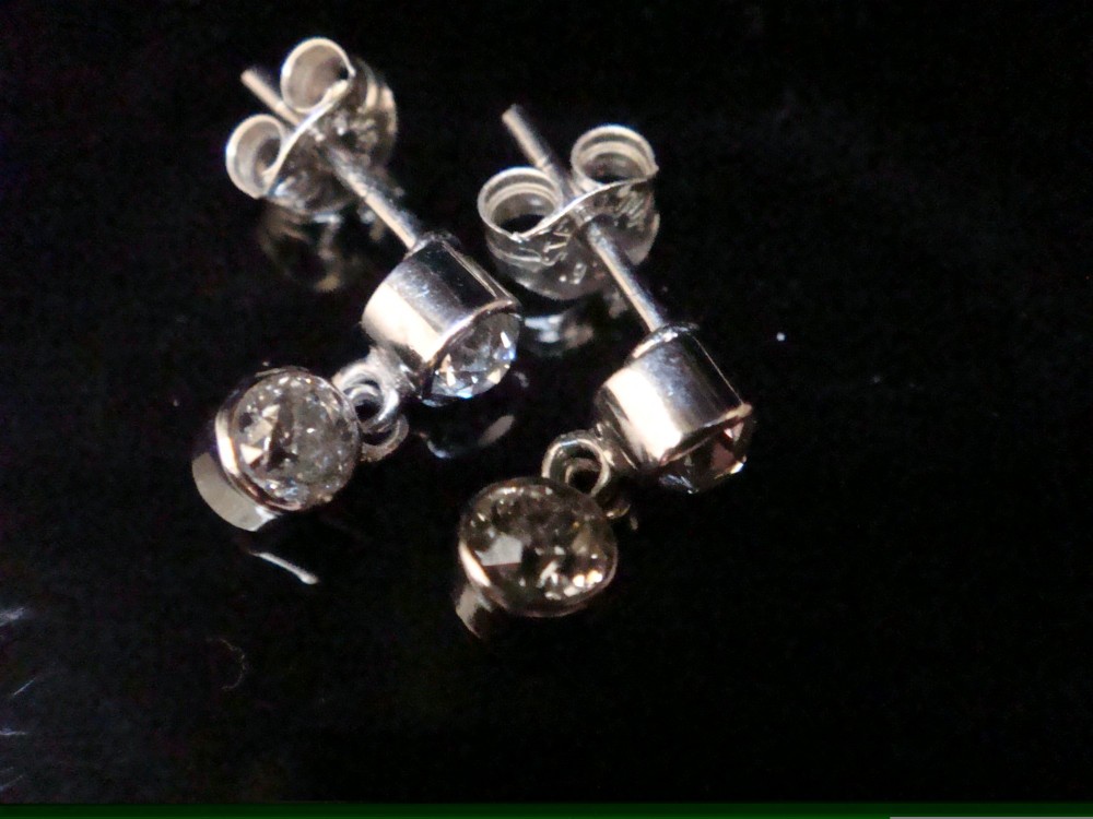 Pair of Edwardian 18ct white gold drop earrings featuring rubover bezel-set old cut diamonds. View VIII