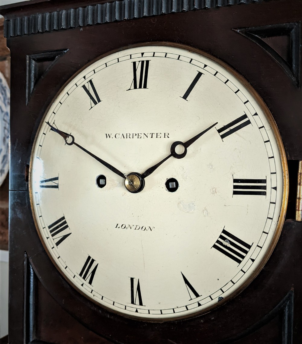 A 19th-century mahogany fusee bracket clock with a brass finial, brass ball feet, fluted wood trim, and a white dial displaying Roman numerals. View VI