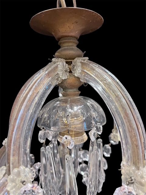 fig 1. A single-light Marie Theresa style chandelier featuring clear glass-sheathed arms, glass rosettes, and suspended cut crystal drops.