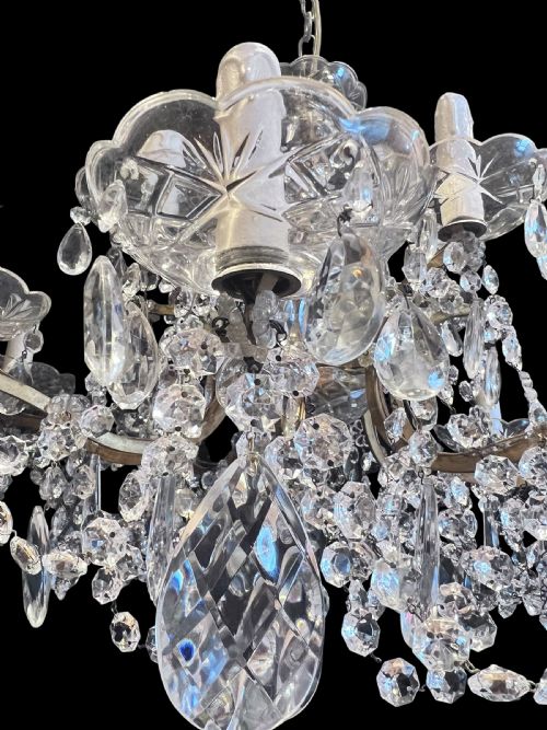 fig 2. A twelve-light antique Italian chandelier featuring two tiers of candle-style bulb holders, cut crystal drops, scalloped bobeches, and glass bead garlands.
