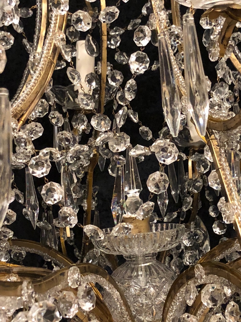 A large Italian Florentine eighteen light chandelier featuring a gilt scroll frame hung with cut crystal drops and glass bead strands. View II