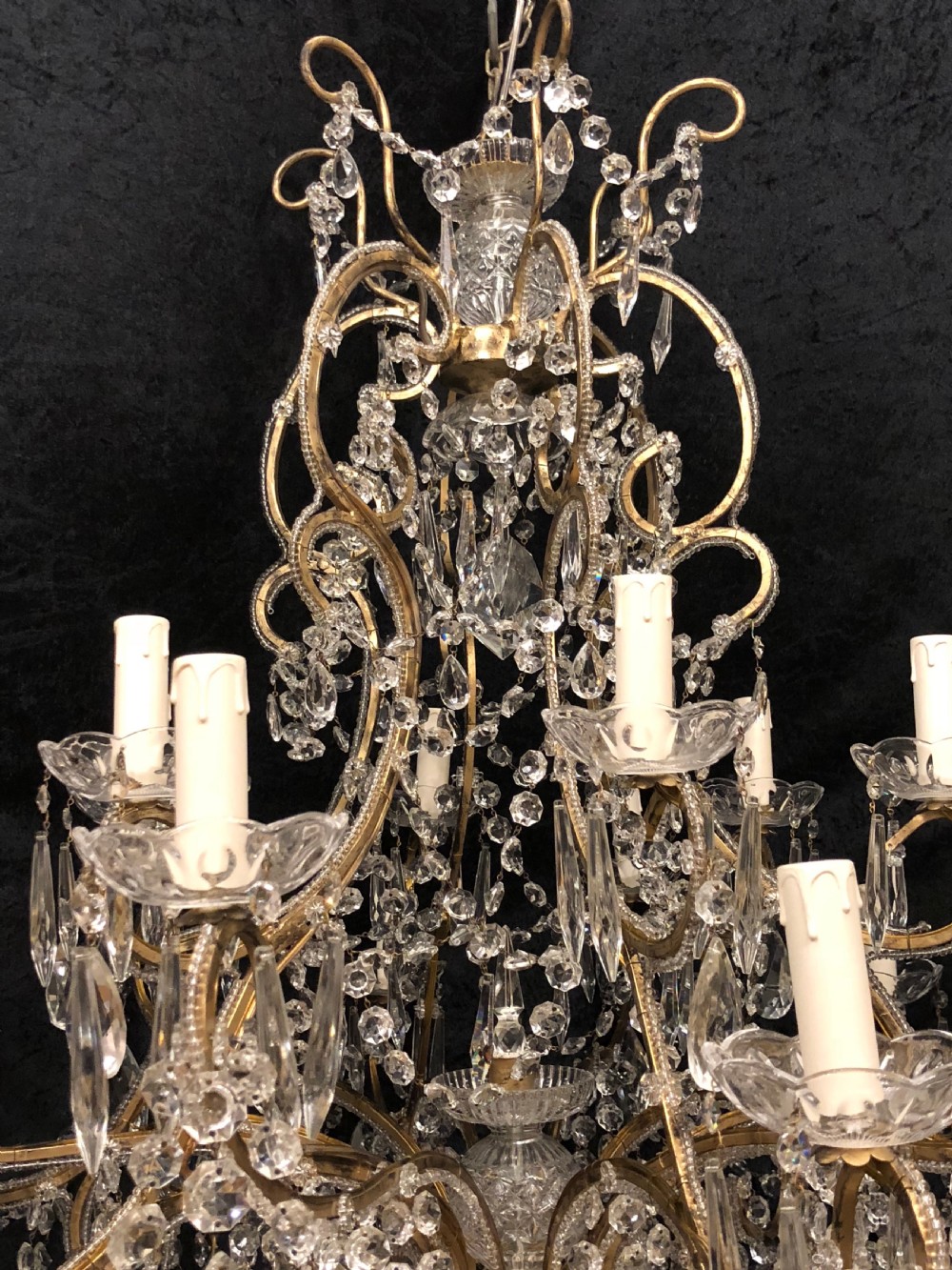 A large Italian Florentine eighteen light chandelier featuring a gilt scroll frame hung with cut crystal drops and glass bead strands. View III