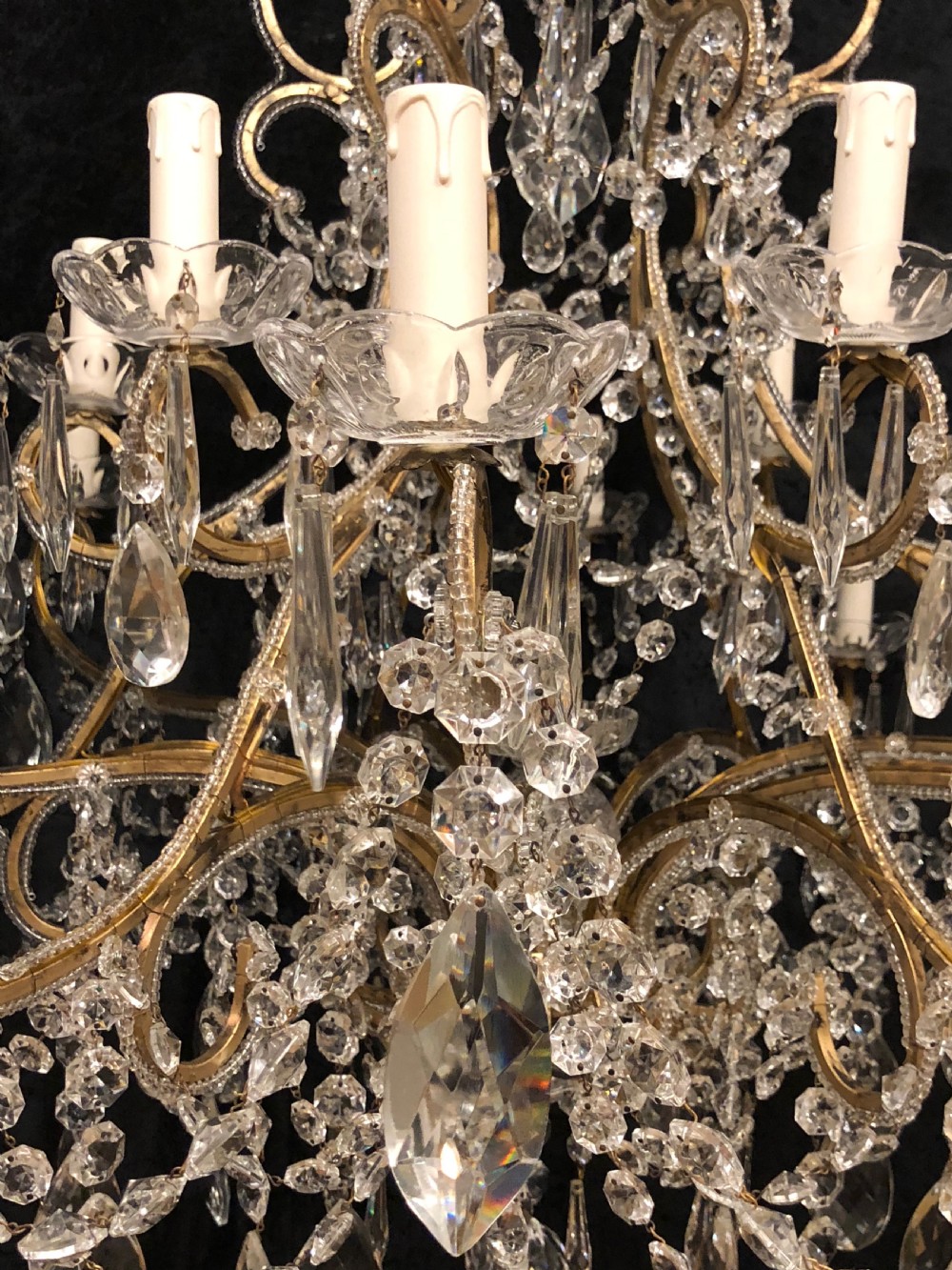 A large Italian Florentine eighteen light chandelier featuring a gilt scroll frame hung with cut crystal drops and glass bead strands. View IV