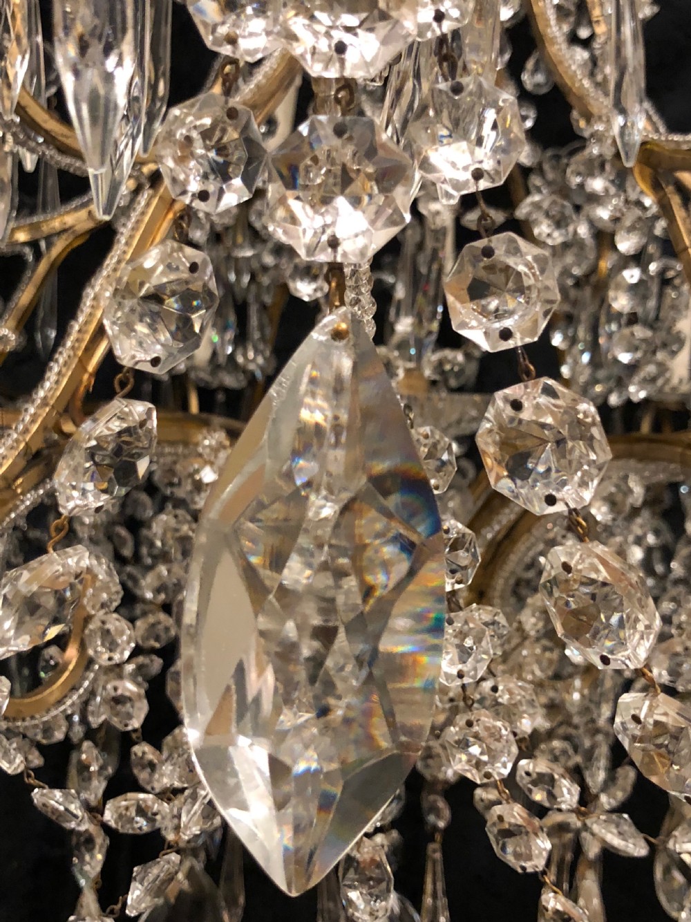 A large Italian Florentine eighteen light chandelier featuring a gilt scroll frame hung with cut crystal drops and glass bead strands. View V