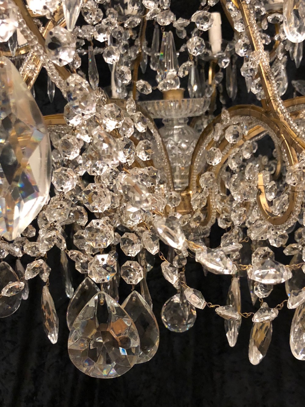 A large Italian Florentine eighteen light chandelier featuring a gilt scroll frame hung with cut crystal drops and glass bead strands. View VII