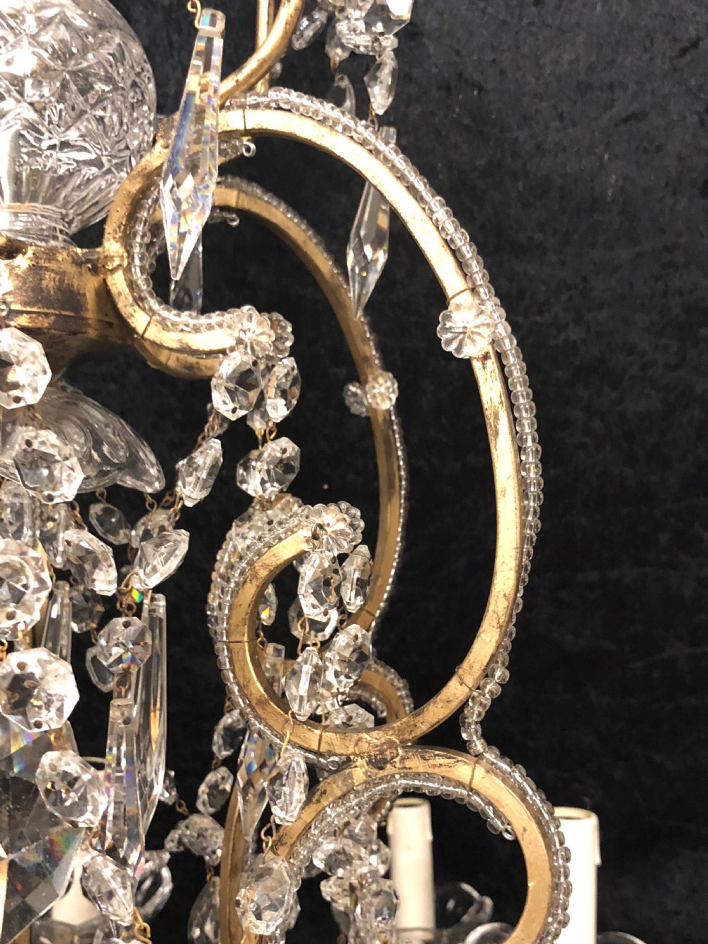 A large Italian Florentine eighteen light chandelier featuring a gilt scroll frame hung with cut crystal drops and glass bead strands. View VIII